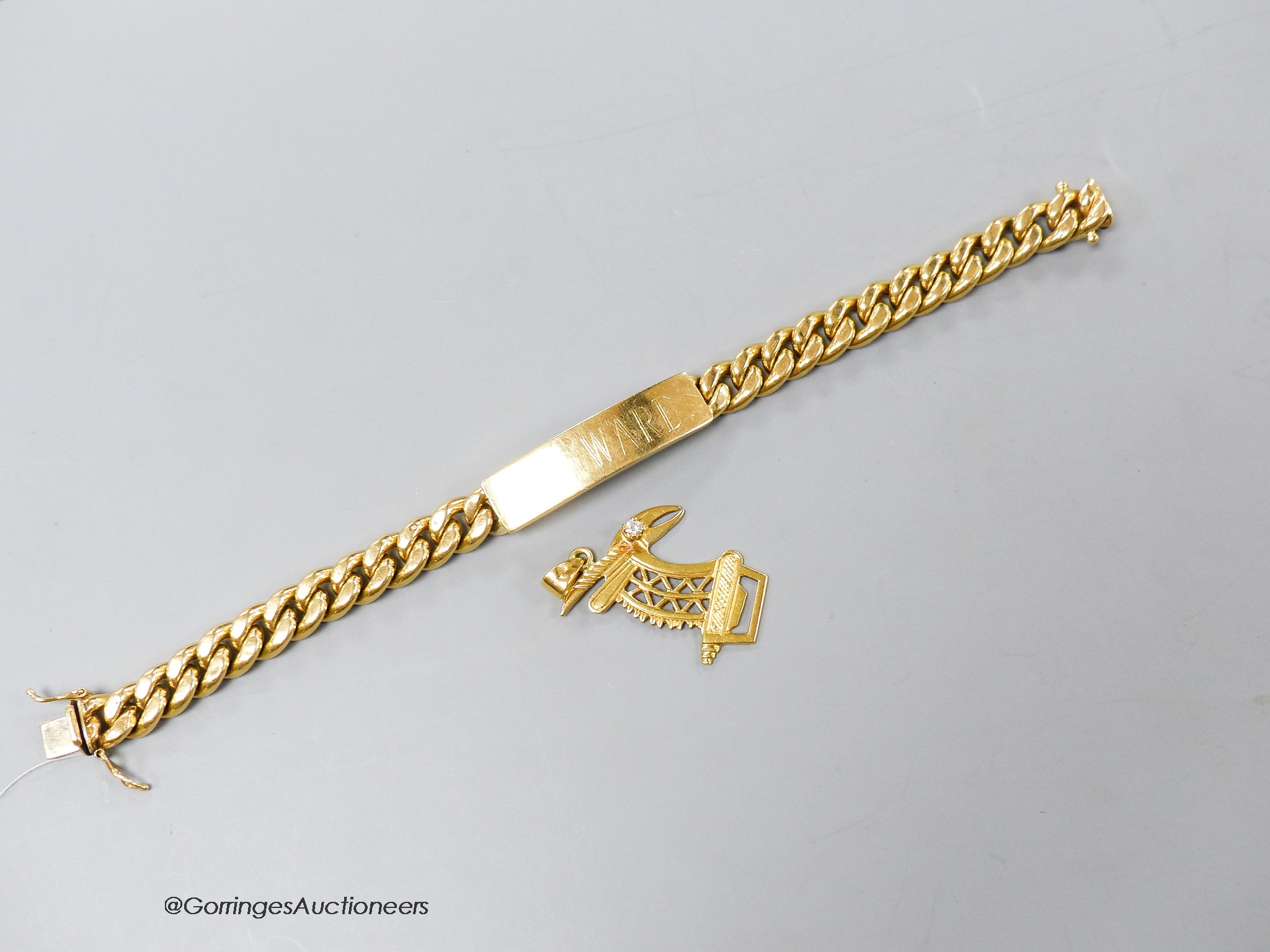 A yellow metal (stamped 750) curb link identity bracelet, 21cm and a 750 and diamond set pendant, 35mm